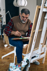 senior man painting at his home