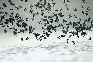Letters of the alphabet falling and flying in levitation in the air