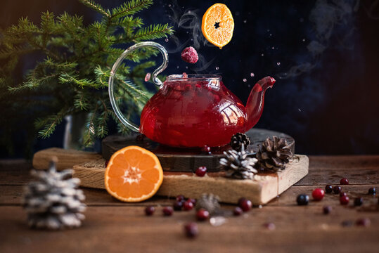 Glass teapot with fruit tea and wild berries and orange