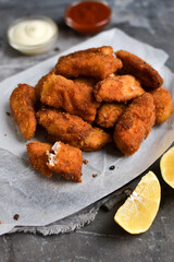 Homemade chicken nuggets. Nuggets on white parchment. Ketchup and mayonnaise. Copyspace. Gray background.