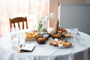 The buffet at the reception. Assortment of canapes on a table. Banquet service. Catering food, snacks with different types of cheese, ham, salami, prosciutto, shrimp, vegetables and fruits. 