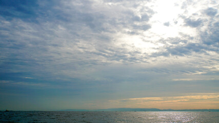 Fototapeta na wymiar 雲の裏に輝く太陽と一面に広がる相模湾の海原