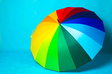 Colored umbrella on a blue background . Bright umbrella. Copy space.
