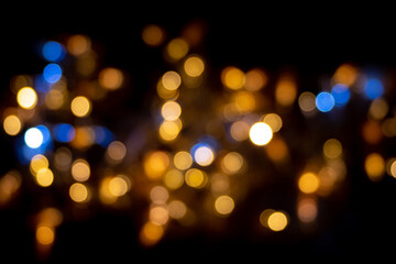 Obraz premium Perfect bokeh for a festive New Year and Christmas background. Defocused abstract yellow and blue light circles. Bokeh spreads from side to side