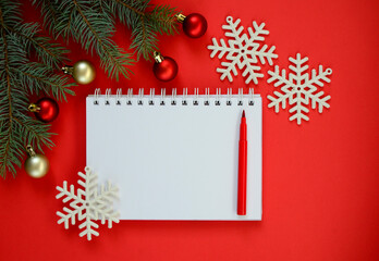 Fototapeta na wymiar New Year goal list 2021. Clean notebook for writing about plan listing of new year goals and resolutions setting on red background with Christmas tree and red glitter balls and snowflakes . Wish list.
