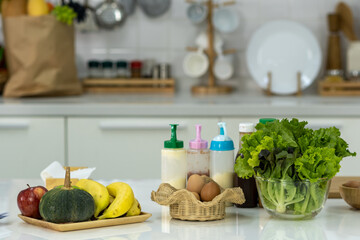 Fruits, vegetables and eggs on the white table in the kitchen.