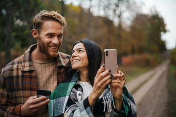 Attractive smiling young couple using mobile phone