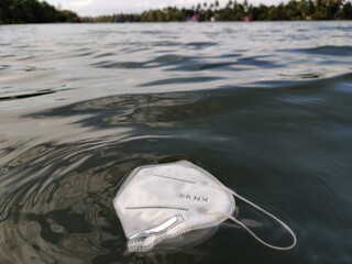 After effect of COVID, N 95 face mask floating on the surface of water,water pollution concept....