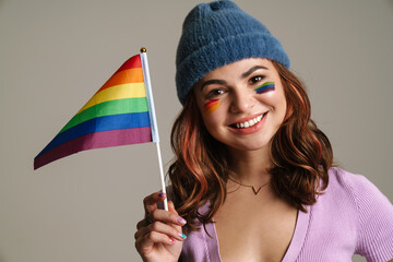 Happy beautiful woman smiling while posing with rainbow flag