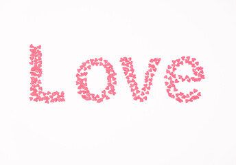 Love word made from pink hearts on a white background. Valentine's day concept. Flat lay, top view.