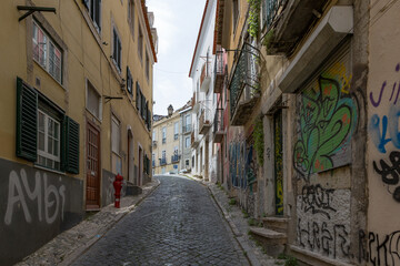 Steep narrow cobblestoned street Calcada Salvador Correia de Sa in Lisbon, Portugal