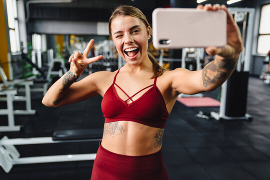 Cheery young woman fitness coach taking a selfie