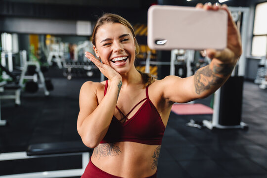 Cheery young woman fitness coach taking a selfie