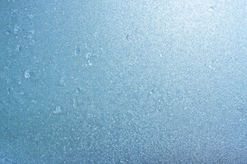 Fototapeta na wymiar Winter background on a transparent glass of a window with a frozen texture. Abstract texture background, horizontal image, copy space for your design or text