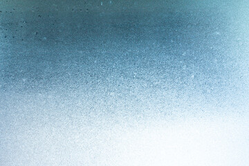 Winter background on a transparent glass of a window with a frozen texture. Abstract texture background, horizontal image, copy space for your design or text
