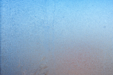 Winter background on a transparent glass of a window with a frozen texture. Abstract texture background, horizontal image, copy space for your design or text