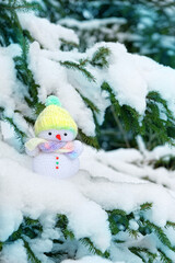 cute snowman and snowy fir tree. winter festive season. Christmas and New Year holiday background. knitted snowman toy