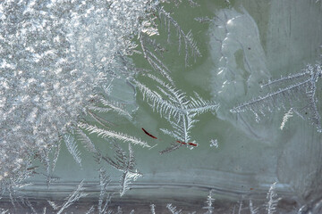 Winter background on a transparent glass of a window with a frozen texture. Abstract texture...