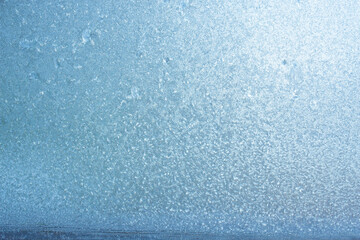 Completely frozen window on transparent glass. Clean background. Extreme low temperatures in winter. Water vapor condenses on cold window glass and freezes