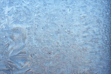 Completely frozen window on transparent glass. Clean background. Extreme low temperatures in winter. Water vapor condenses on cold window glass and freezes