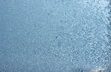 Completely frozen window on transparent glass. Clean background. Extreme low temperatures in winter. Water vapor condenses on cold window glass and freezes