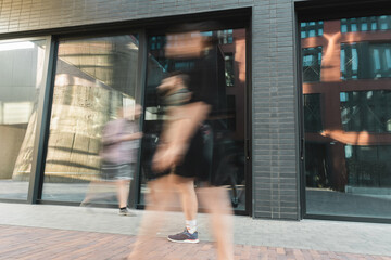 citizens walking on street near modern building, long exposure