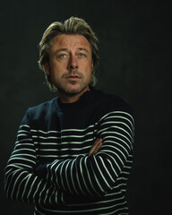 Man with blonde hair in striped fisherman's sweater. Studio portrait.