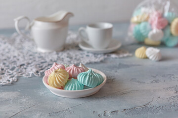 Meringues of a delicate pastel color are on the table for morning tea
