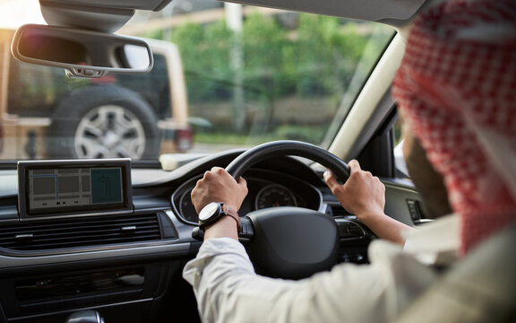 Rear View Of Arab Man Driving Car In Rush Hour Traffic Using Gps Navigation