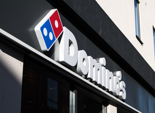 Exterior shot of Dominos Pizza Take Away Food Chain.  Sign and logo