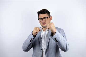 Business young man wearing a casual shirt over white background Punching fist to fight, aggressive and angry attack, threat and violence