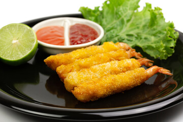 breaded shrimp on black plate isolated on white background