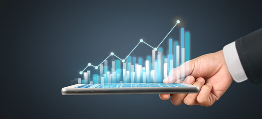Graph growth and increase of chart positive indicators in his business,tablet in hand