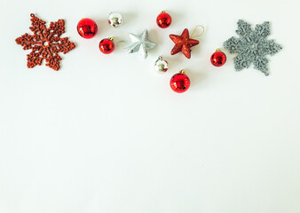 Arrangement of christmas ball ornaments, stars and snowflakes on an isolated white surface with copy space, top view