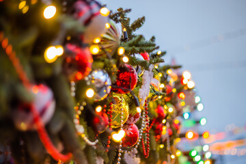 Christmas tree decorations, balls and toys with garland on street at evening - close up. Holiday, celebration, traditional and new year concept