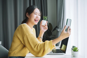 Attractive asian woman posing and taking a selfie at her home.