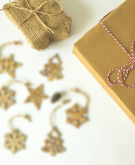 Christmas present boxes with wooden christmas ornaments and a pine cone on an isolated white surface, top view