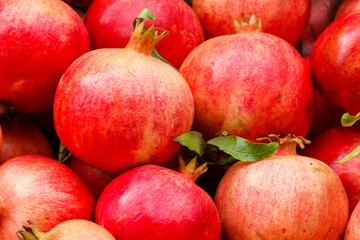 Heap of fresh pomegranates for sale in market. Background of pomegranate fruits