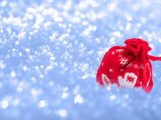 Red bag with Christmas gifts on a blue snow background.