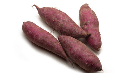 A group of raw sweet potatoes on isolated white background. Selective focus on foreground.