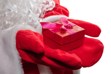 High angle close up shot of Santa Claus's hands holding a red gift box with a purple ribbon. Hands covered with red gloves. Christmas gift concept. Isolated on white background