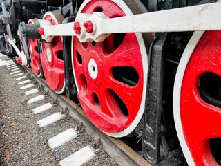 massive red-black wheels of a steam locomotive.