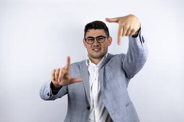Business young man wearing a casual shirt over white background smiling making frame with hands and fingers with happy face