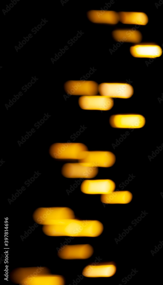 Poster bright yellow lights and sparks in defocus. bokeh effect on black background for overlay.