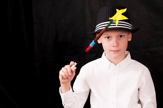 Child with magic wand and hat and white shirt