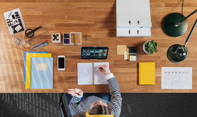 Top view of businesswoman working on tablet at desk in home office, video call concept.