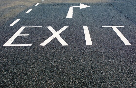 Road markings with the word, 'EXIT' with a directional arrow painted in white.