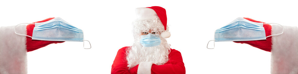 Angry Santa Claus wearing medical mask, arms crossed on his chest. Close up shot of two other Santas' hands extending medical masks to him. Isolated, white background. Pandemic holidays concept