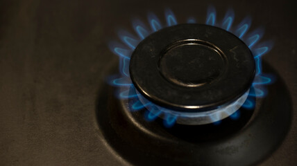 lit gas burner on the gas surface of an anthracite-colored stove