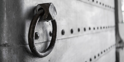 Big rough ring handle hangs on vintage metal castle door